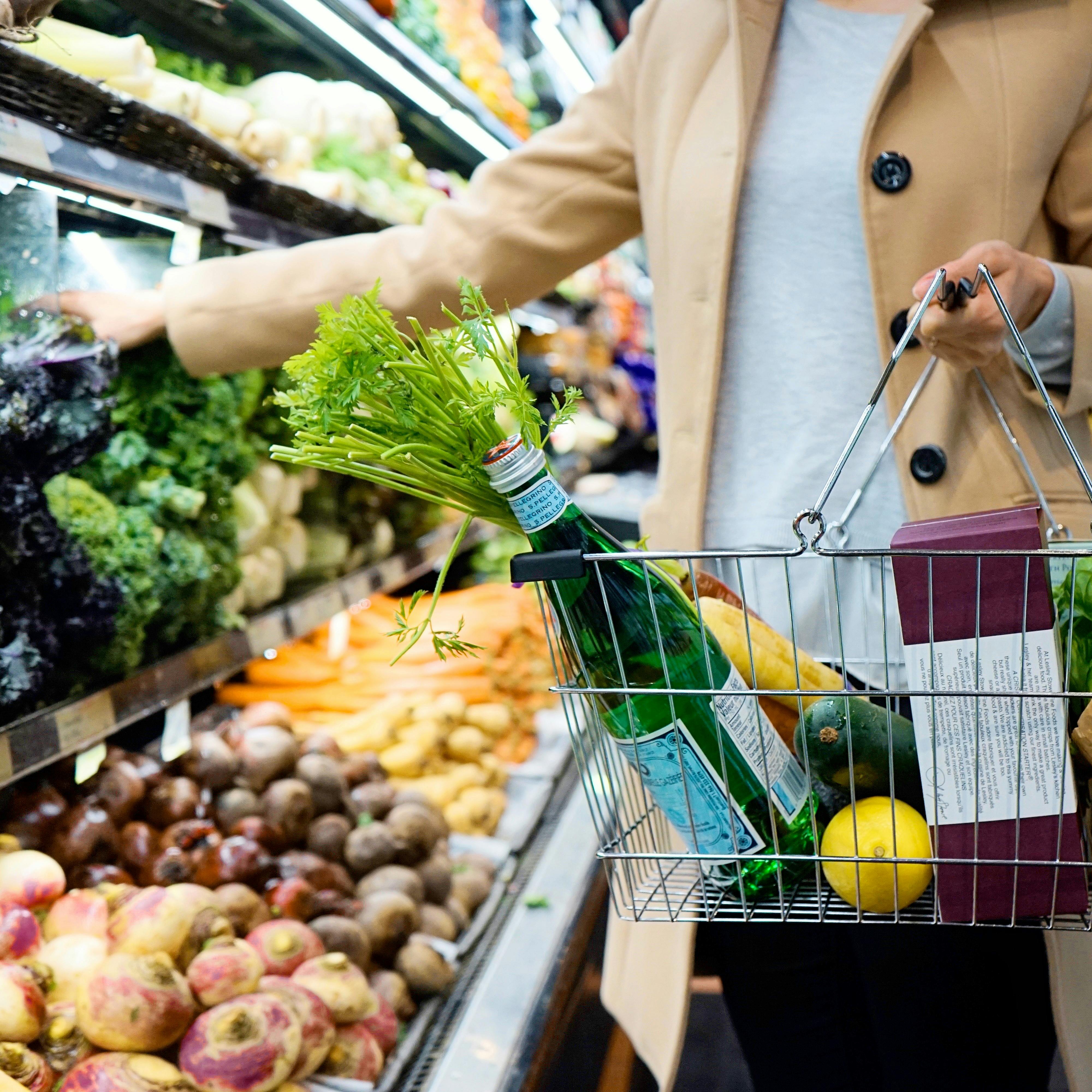 Solución para supermercados Mujer cogiendo llenando la cesta con varios productos en un supermercado