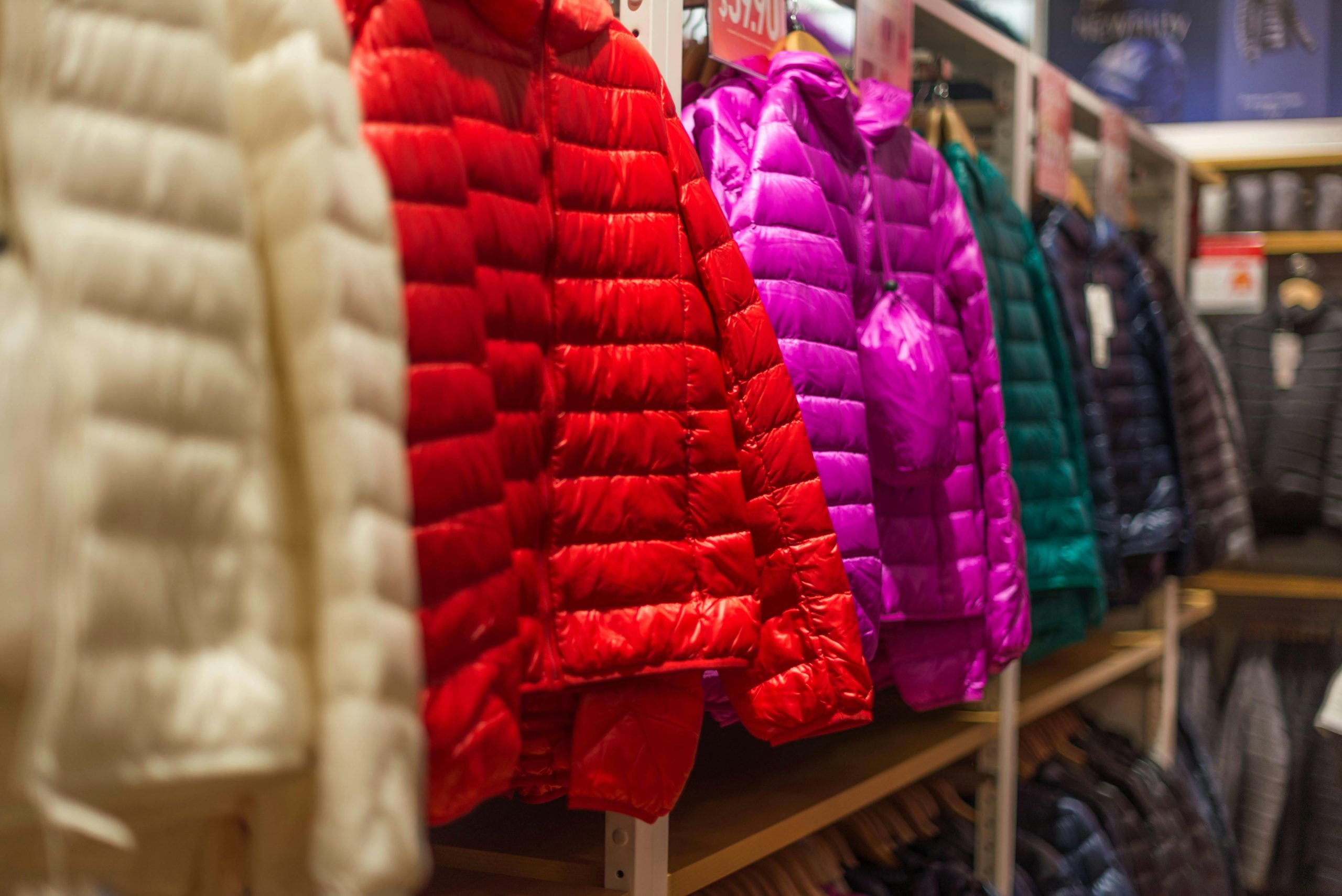 Interior de una tienda de ropa donde hay varias chaquetas impermeables